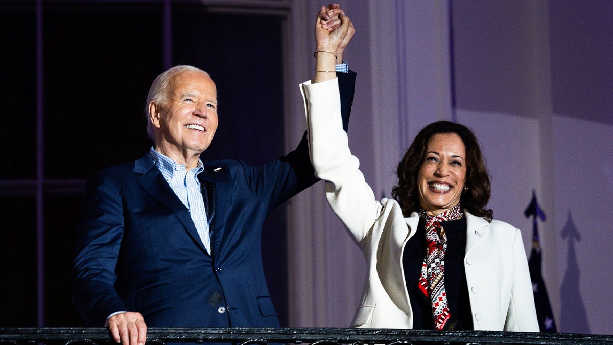 Predsjednik Joe Biden i potpredsjednica Kamala Harris drže se za ruke na balkonu