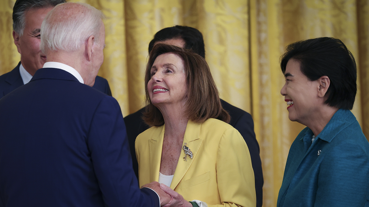 Nancy Pelosi, desno, s predsjednikom Bidenom lijevo gledano s leđa