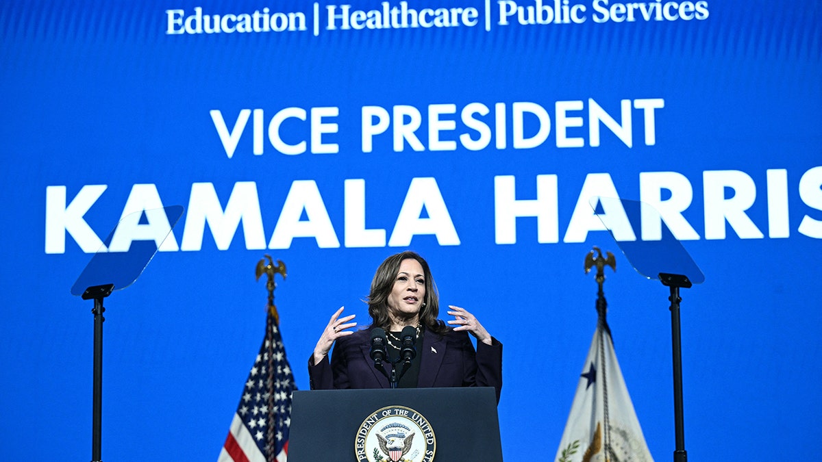 Kamala Harris govori ispod velikog plavog znaka