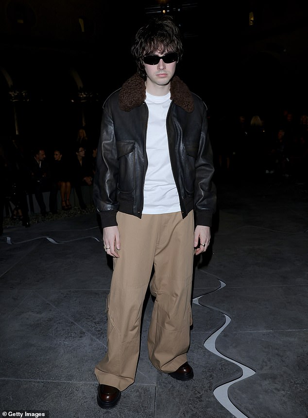 He stepped out in a white T-shirt and tan wide-leg trousers, teamed with a leather shearling jacket