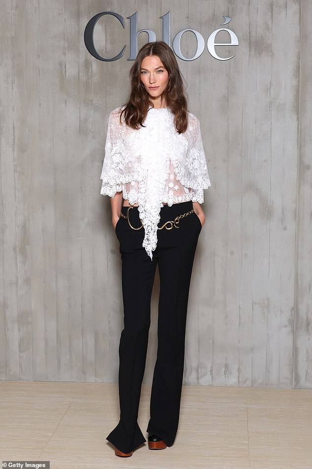 Karlie Kloss showed off her slender figure in a low-waisted black trousers and a white lacy top