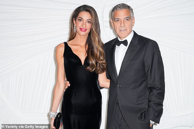 Amal accessorized the dress with a pair of dangly, silver earrings as well as dazzling, silver bracelets on her right wrist