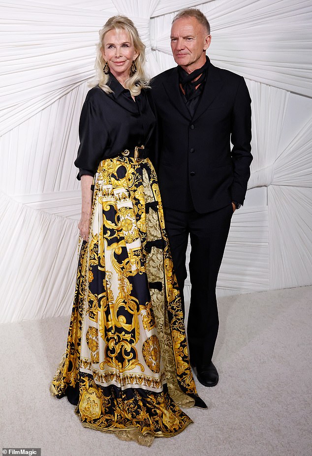 Trudie Styler was stylish in a black, satin blouse which was tucked in the waist of a long, patterned skirt that had hues of yellow, white and black