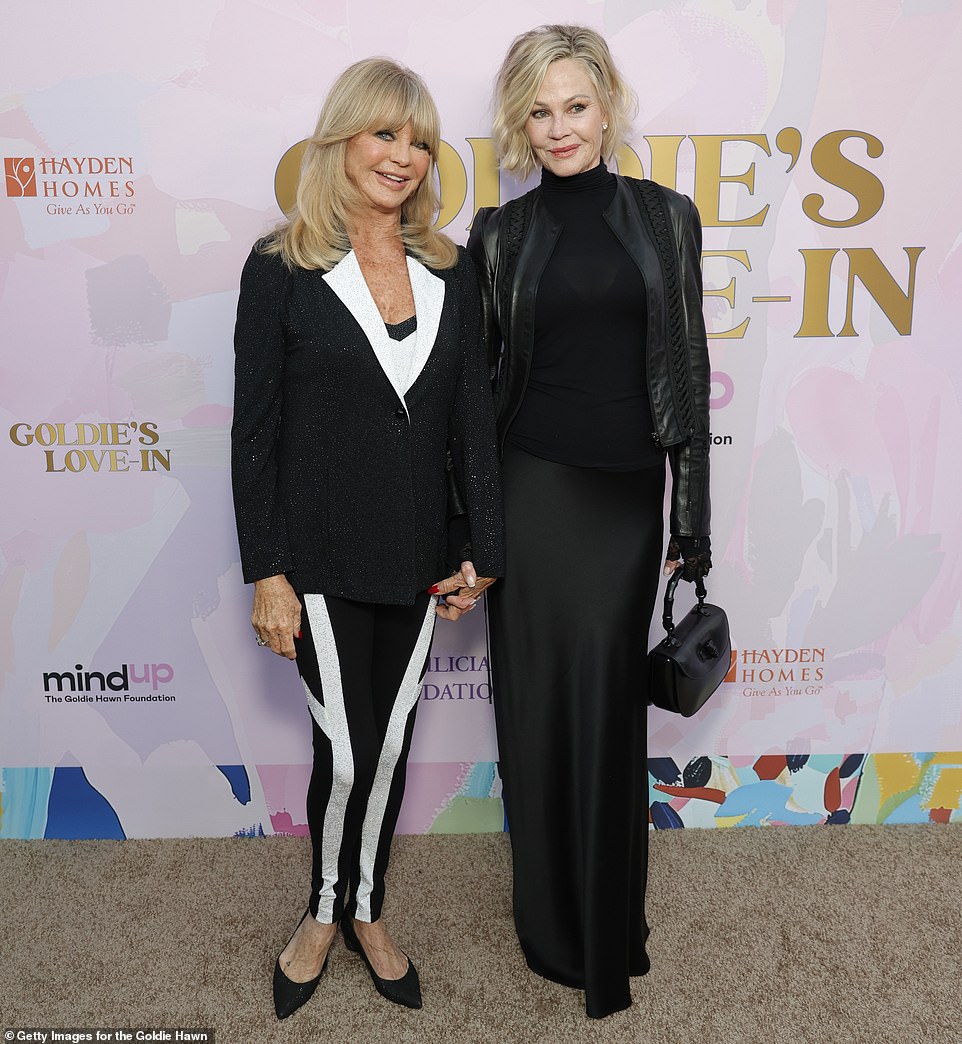 Melanie carried a black purse in her left hand to complete her fashionable ensemble and also crossed paths with Goldie during a photo session