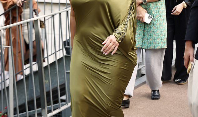 Ashley Graham naglašava svoje obline u maslinastoj svilenoj haljini na jedno rame dok prisustvuje modnoj reviji Atlein tijekom Pariškog tjedna mode