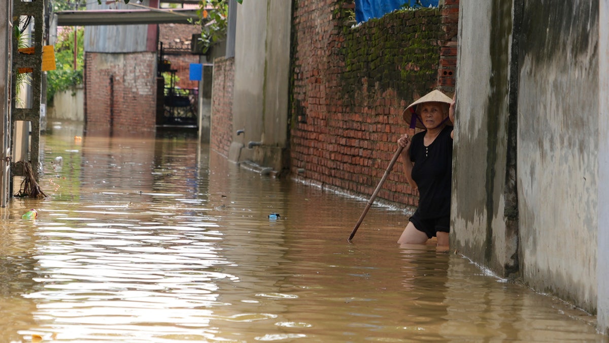 Žena gazi u poplavi nakon tajfuna Yagi u selu An Lac, Hanoi, Vijetnam, petak.