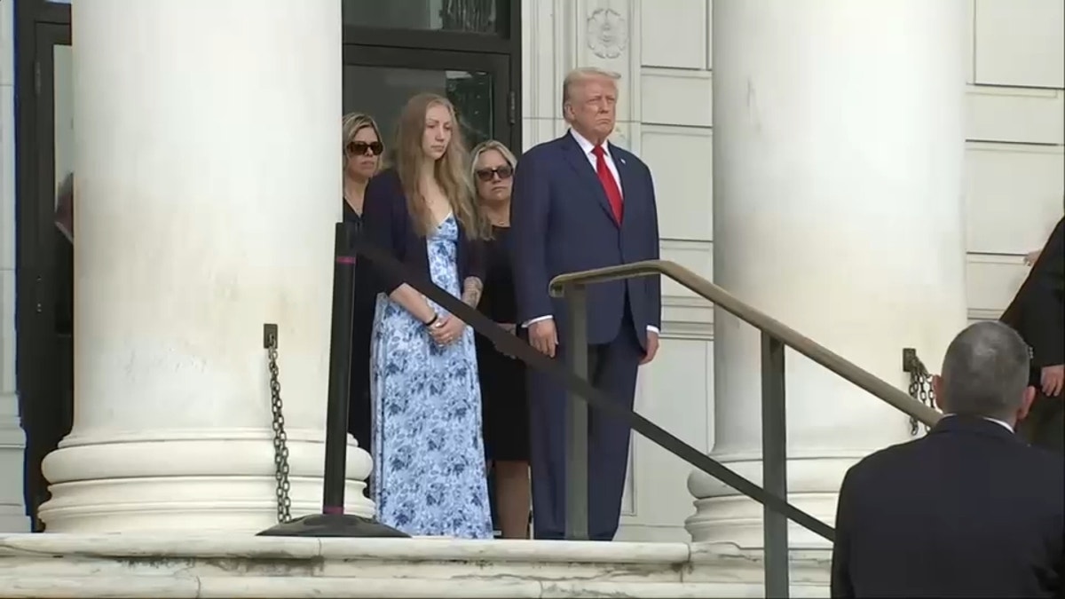 Trump stoji na stepenicama s mladom ženom na ceremoniji polaganja vijenca u Arlingtonu