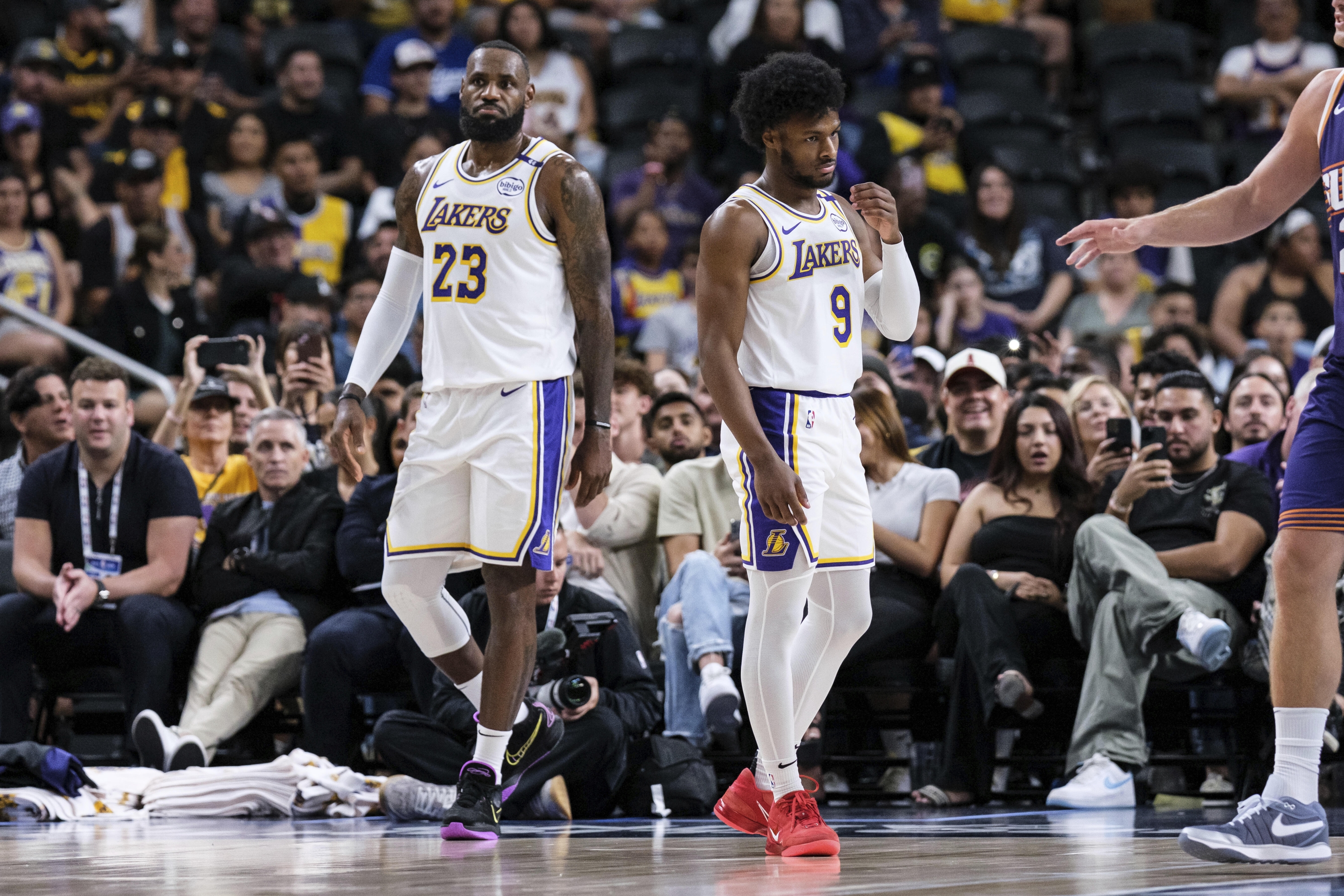 Stražar Los Angeles Lakersa Bronny James (9), desno, ulazi u igralište s napadačem LeBron Jamesom (23) tijekom prvog poluvremena predsezonske NBA košarkaške utakmice protiv Phoenix Sunsa, nedjelja, 6. listopada 2024., u Palm Desertu, Kalifornija (AP Photo/William Liang) Associated Press / LaPresse Samo Italija i Španjolska