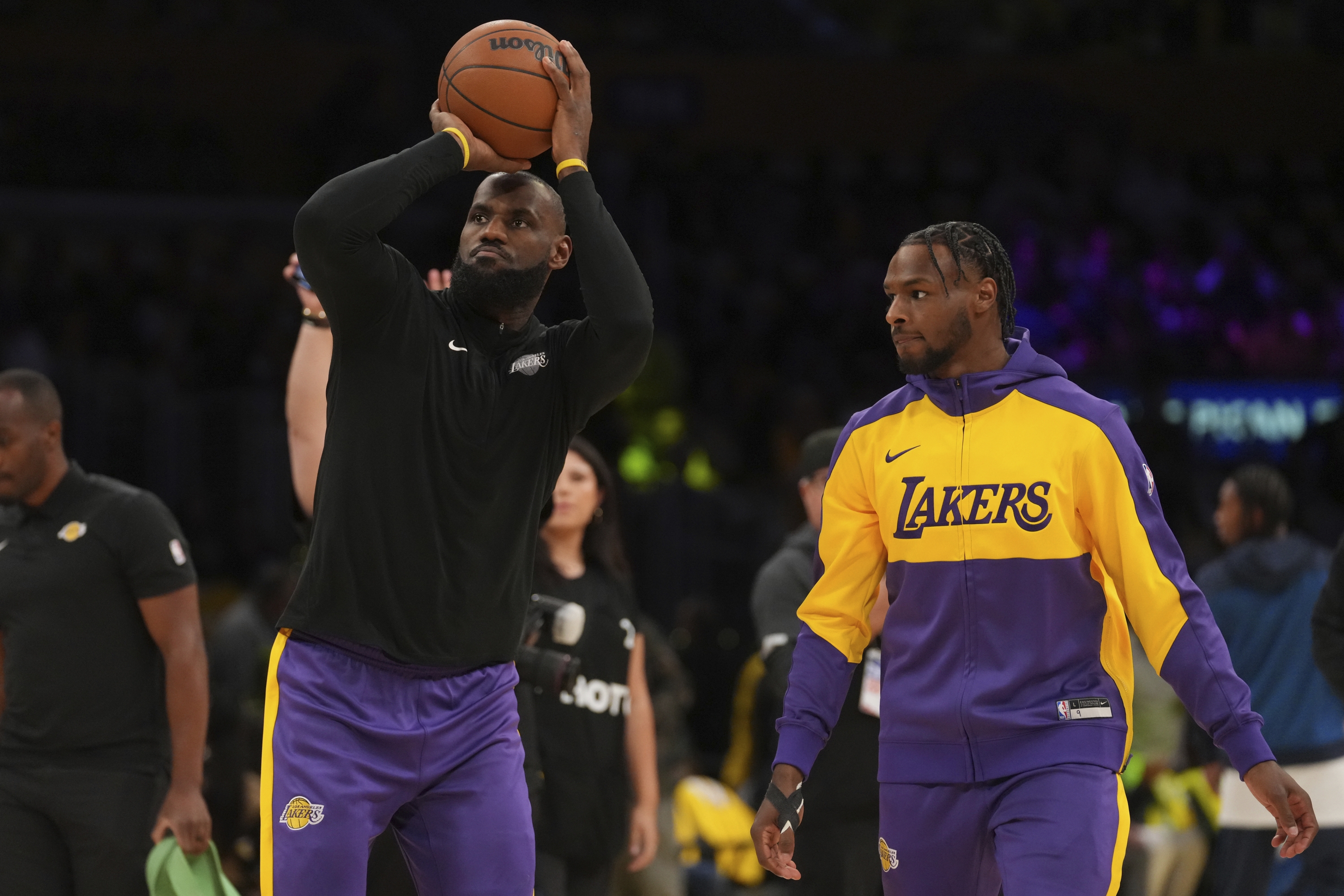 Napadač Los Angeles Lakersa LeBron James, lijevo, i stražar Bronny James zagrijavaju se prije NBA košarkaške utakmice protiv Minnesota Timberwolvesa, utorak, 22. listopada 2024., u Los Angelesu. (AP Photo/Eric Thayer)