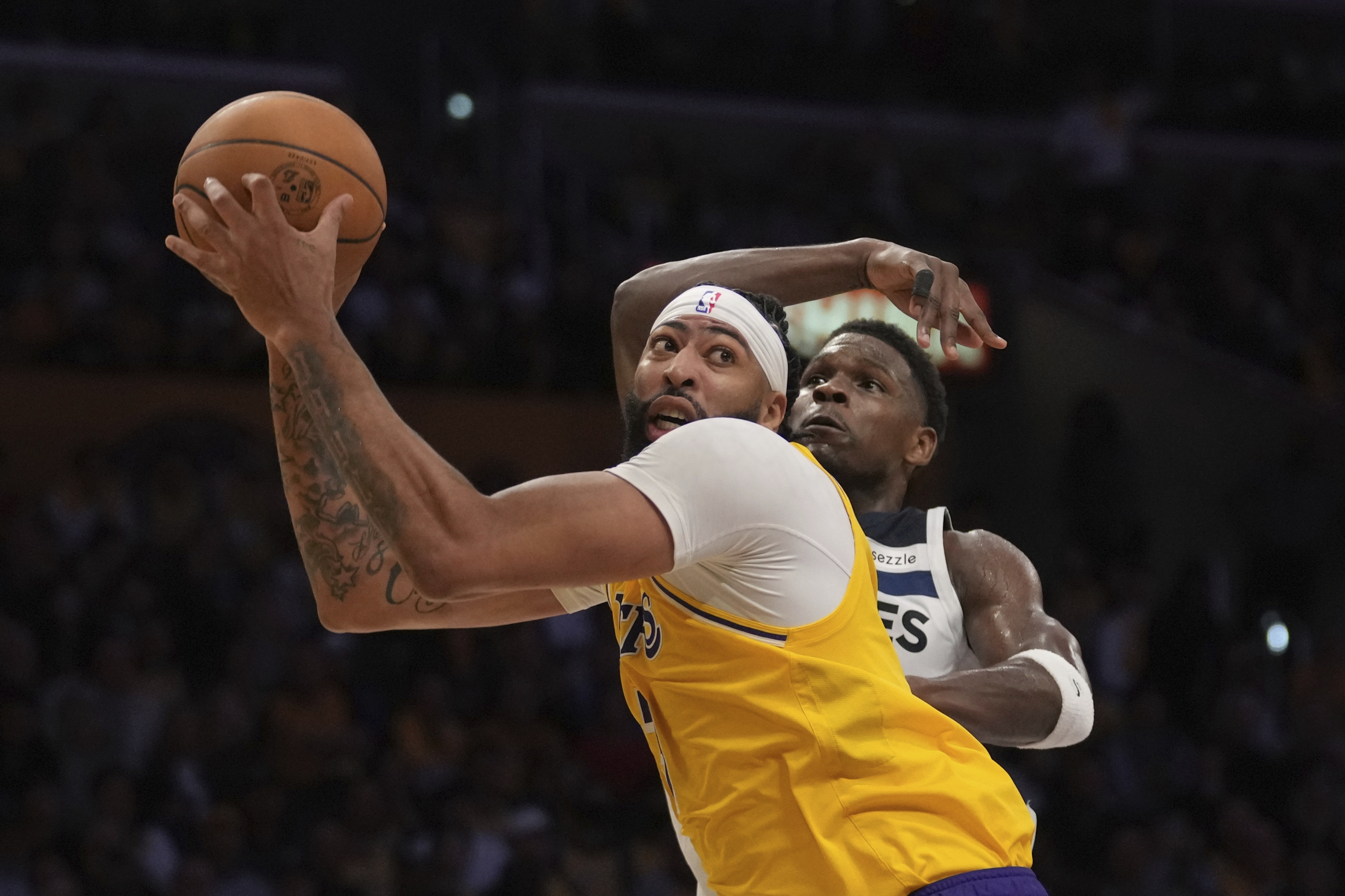 Napadač Los Angeles Lakersa Anthony Davis, naprijed, rukuje loptom dok čuvar Minnesota Timberwolvesa Anthony Edwards brani tijekom drugog poluvremena NBA košarkaške utakmice, utorak, 22. listopada 2024., u Los Angelesu. (AP Photo/Eric Thayer)