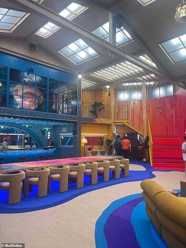 The living room and kitchen space followed a theme of red, blue, and yellow, with an assortment of funky decor from patterned vases to giant potted plants