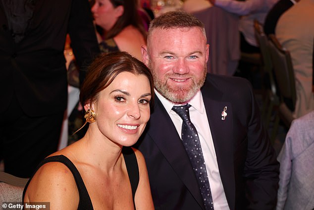 The couple beamed for a photo while sat at their table