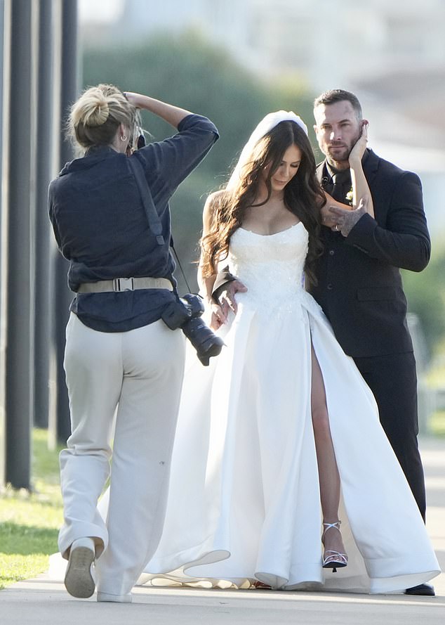 Taylor stunned in a sleeveless white wedding gown with a sparkling bodice with embroidered details and added a pair of strappy silver heels