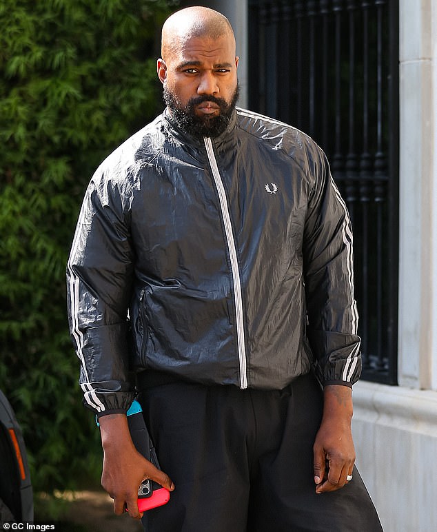 Kanye West is leading an 'upper class homeless ' life in a glamorous Asian metropolis while working on his next album Bully, it is claimed; pictured this March in Los Angeles