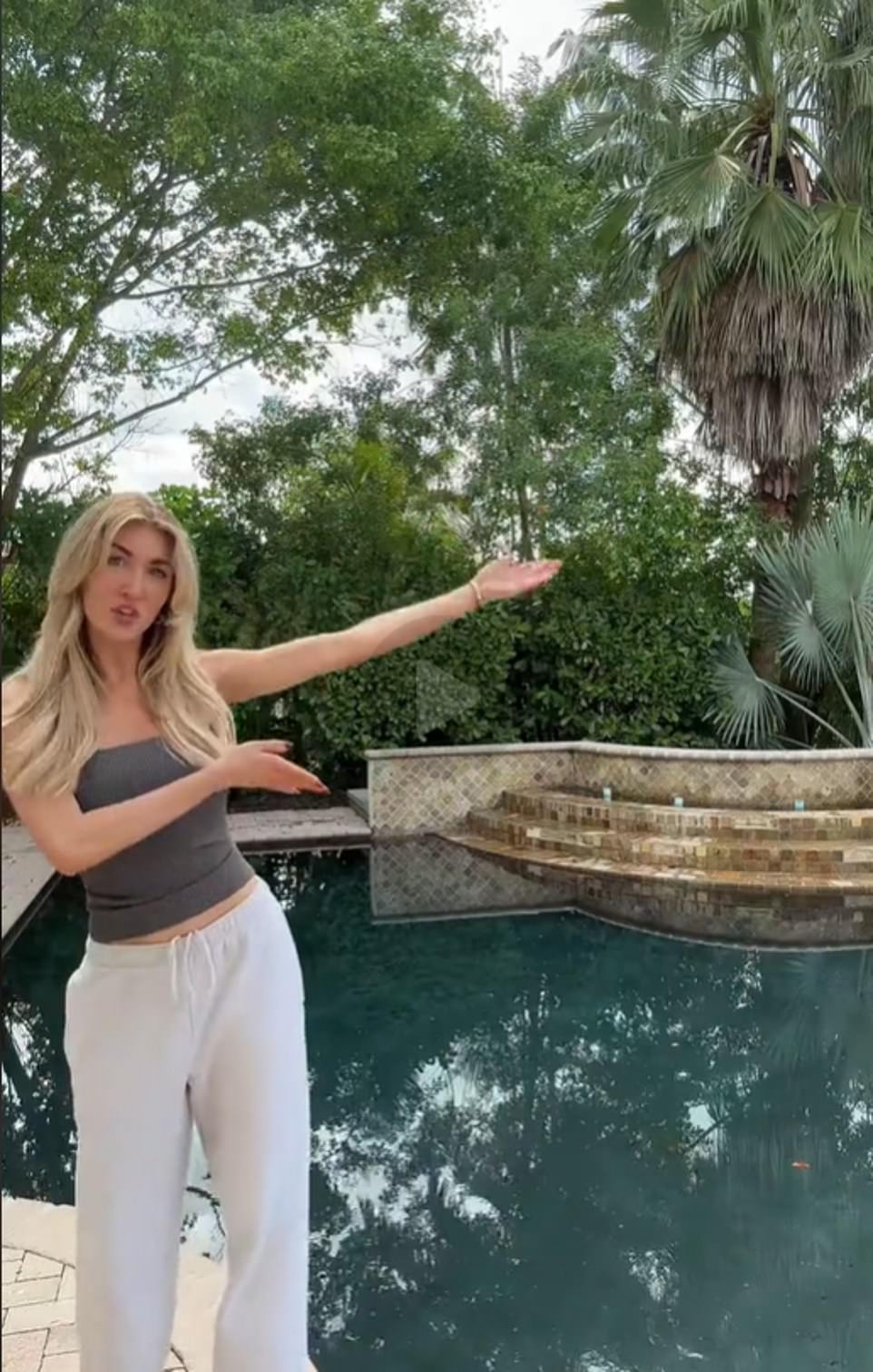 In a strapless gray top and sweatpants for one of the first, the influencer stands outside in front a palm tree, throws her arm in the direction of the home and says: 'I'm always doing little hotel tour.. and we just moved so I figured I'd do a mini house tour'