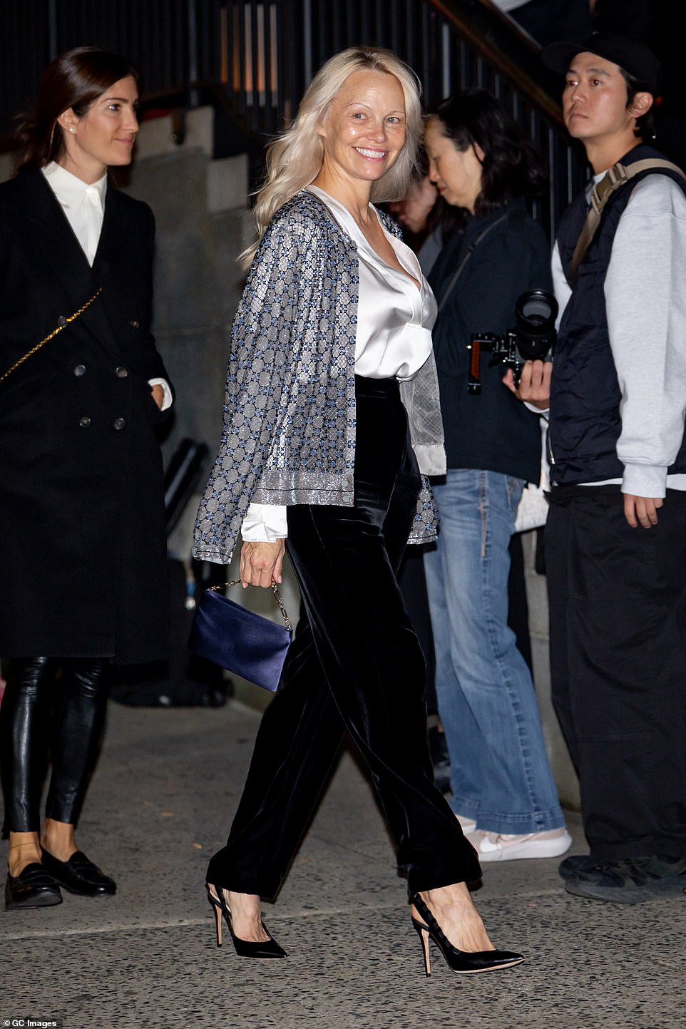 She completed her outfit with sky-high slingback heels and a blue satin purse with a beaded strap