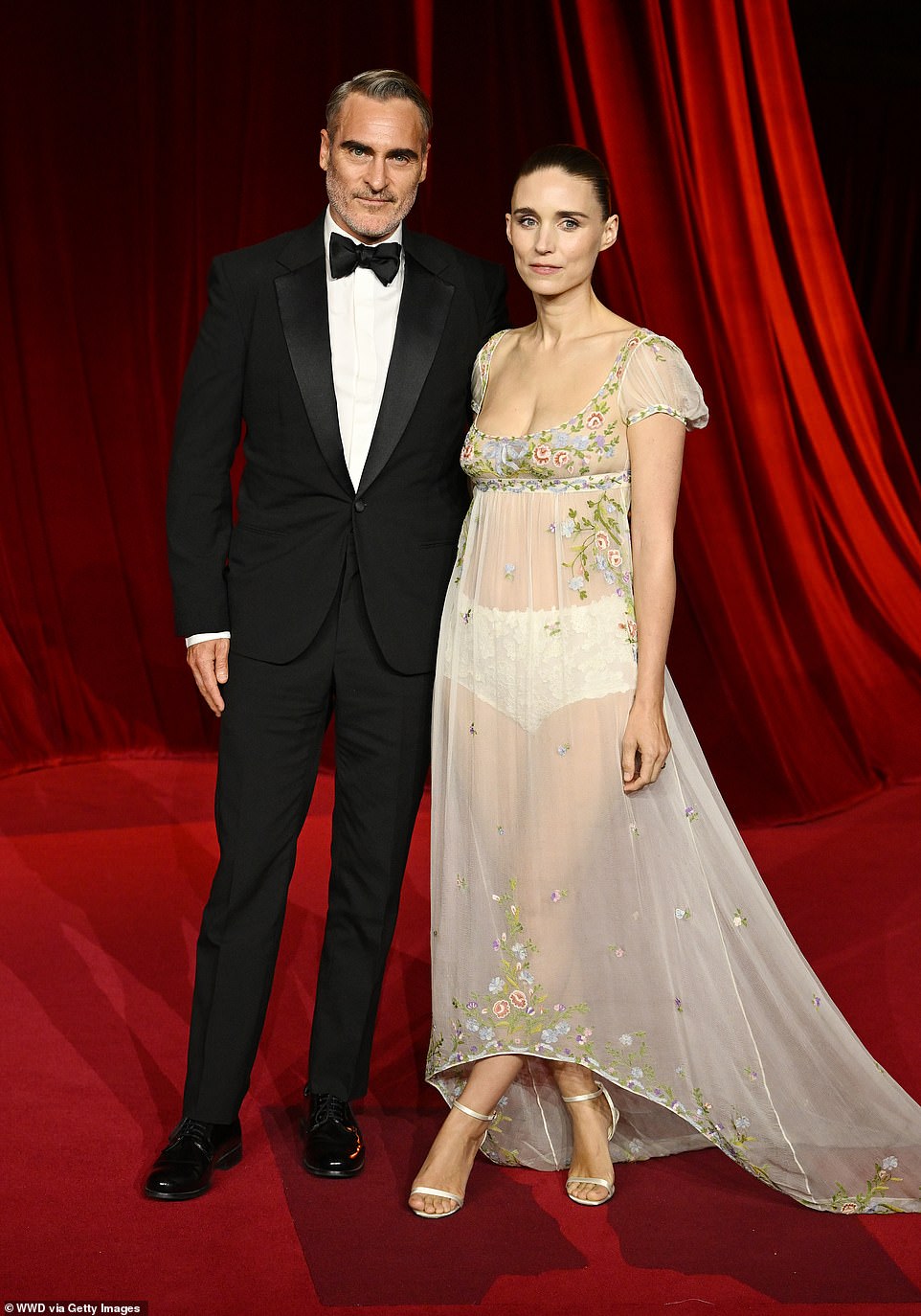 Joaquin Phoenix and Rooney Mara were another stylish pair on the red carpet. The Joker star sported a classic black-and-white tuxedo while his partner donned a sheer gown with intricate, floral embroidery. The actress left little to the imagination as she only sported a pair of lace micro shorts underneath her slip dress