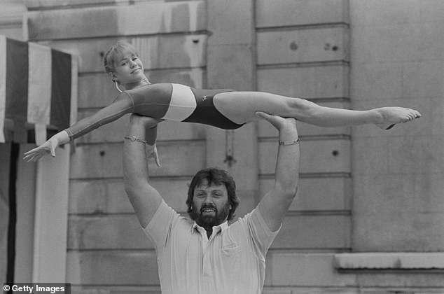 Capes holding gymnast Amanda Gibbons at the launch of the SportsAid Trust in London, UK, 13th July 1984