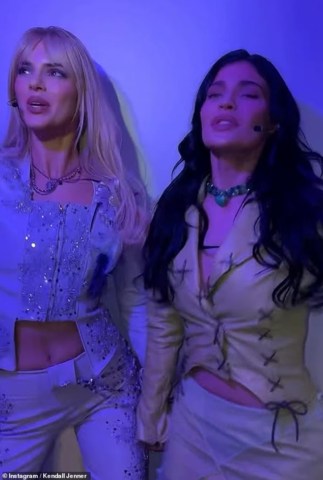 Mimicking Isabella's dark locks, Kylie wore her brunette tresses in soft waves and opted for glamorous make-up, while accessorising with a black headset