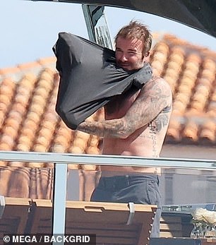 After a little too much tanning David pulled on a dark grey T-shirt