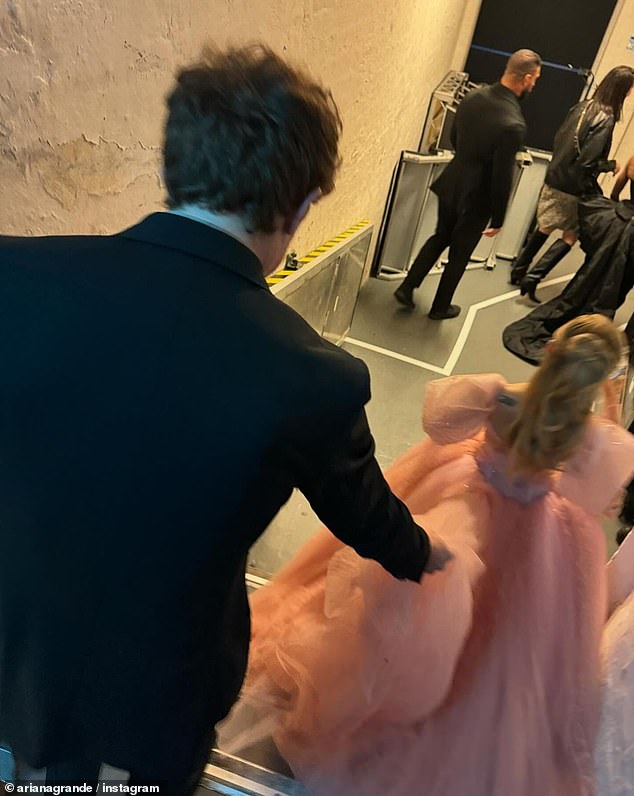 Ariana je podijelila ovu snimku Ethana kako drži njezinu haljinu tijekom novinarske turneje u Sydneyu - jasan znak da su par