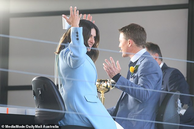 She was seen trying to fix the giant accessory into her tresses as her co-host Alex watched on as she appeared to be deciding about the accessory