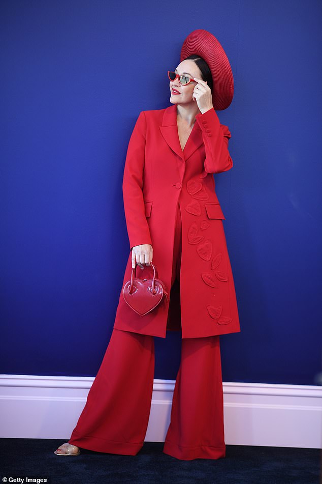 She completed her look with a red love heart handbag and sported some colour coordinated shades on the day