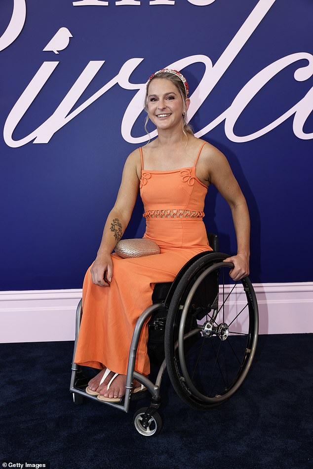 Emma Booth cut a stylish figure in a fashionable orange dress, which she styled with a beaded hairband and metallic clutch bag