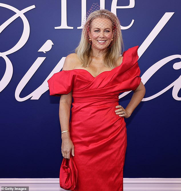 In line with the apparent all-red outfit theme, she toted her essentials in a small rouge clutch bag and fixed a subtle fascinator into her golden locks