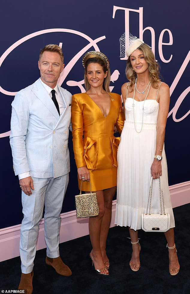 The couple were seen posing up a storm alongside jockey Michelle Payne (centre), who made sure to turn heads in a bold gold mini dress