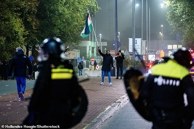 Prosvjednik s palestinskom zastavom i mobilnom jedinicom (ME) tijekom propalestinskih demonstracija tijekom Ajax - Maccabi Tel-Aviv na Anton de Komplein