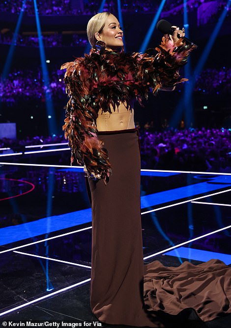 Vruće na petama bio je još jedan pogled koji je blještao od trbušnjaka kad je izašla na pozornicu u prekrasnom kratkom topu s perjem i pripijenoj maxi suknji