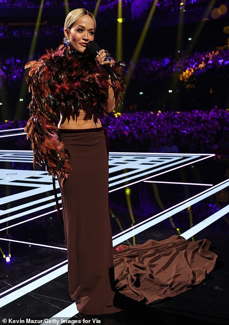 Vruće na petama bio je još jedan pogled koji je blještao od trbušnjaka kad je izašla na pozornicu u prekrasnom kratkom topu s perjem i pripijenoj maxi suknji