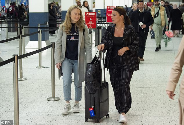 Cutting a chic figure for her travels, Coleen donned a loose-fitting black blazer with a white pattern and matching trousers by Toteme