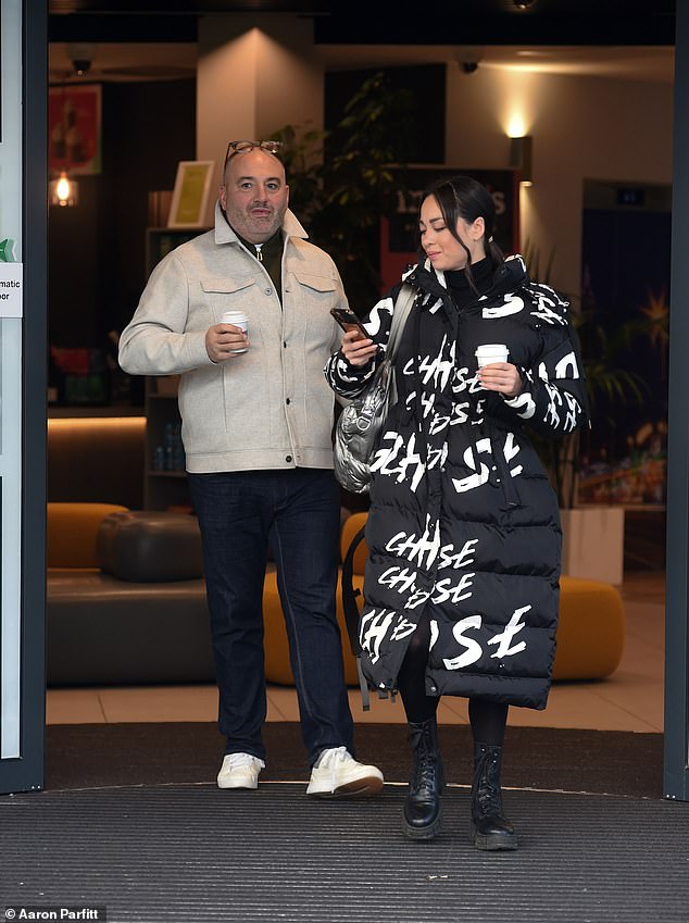 Zvijezda je odjenula krem ​​jaknu na kopčanje koju je kombinirala s crnim hlačama i bijelim tenisicama, dok se Katya ugrijala u dugi crni podstavljeni kaput s bijelim script dizajnom