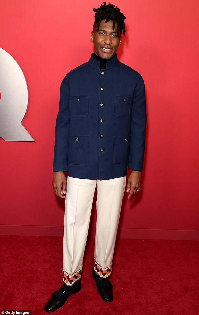 Jon Batiste was fashionable wearing a pair of white pants with a patterned hem as well as a dark navy blazer