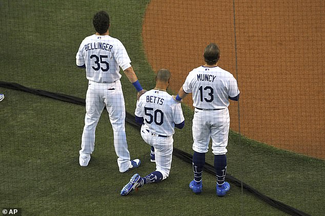 Cody Bellinger and Max Muncy showed their support for Dodgers teammate Mookie Betts by standing beside him with their arms on his shoulders as he kneeled