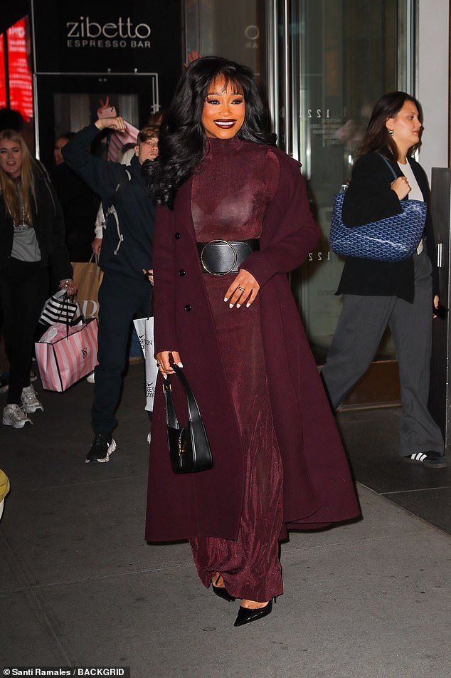 Njezini gavranovi uvojci bili su oblikovani u voluminozne kovrče dok su joj pramenove šiške uokvirivale lice