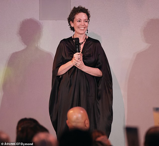 Colman put on a glamorous display wearing a dark gray, satin dress that had caped sleeves and ruched details around the upper portion
