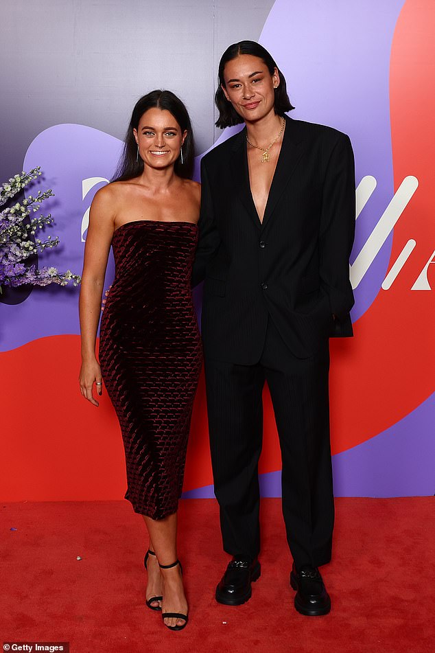 Jesse Wardlaw of the Saints posed alongside her date for the evening while turning heads in a tailored suit under which she went topless