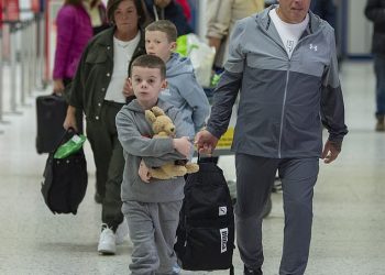 Coleen Rooney’s youngest children Kit, seven, and Cass, six, clutch Wayne figurine as they jet to Australia with their grandparents for an emotional reunion
