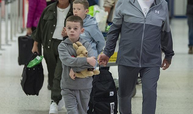 Coleen Rooney’s youngest children Kit, seven, and Cass, six, clutch Wayne figurine as they jet to Australia with their grandparents for an emotional reunion