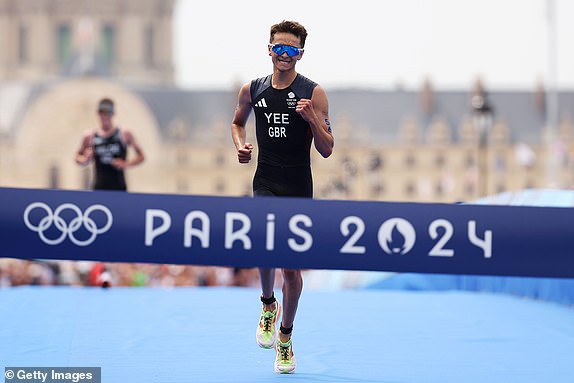 PARIS, FRANCE - JULY 31: Alex Yee of Team Great Britain crosses the finish line to win gold during Men's Individual Triathlon on day five of the Olympic Games Paris 2024 at Pont Alexandre III on July 31, 2024 in Paris, France. (Photo by Ezra Shaw/Getty Images)