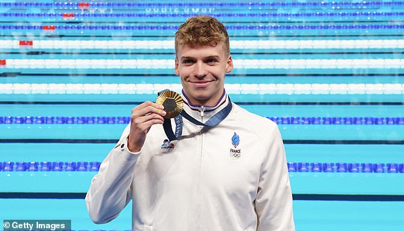 NANTERRE, FRANCE - JULY 28: Leon Marchand of Team France poses with his Gold medal after his victory in the Men's 400m individual medley final on day two of the Olympic Games Paris 2024 at Paris La Defense Arena on July 28, 2024 in Nanterre, France.  (Photo by Xavier Laine/Getty Images)