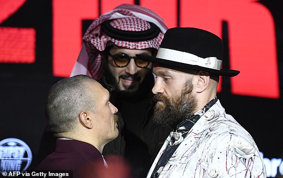 TOPSHOT - Britanac Tyson Fury (desno) i Ukrajinac Oleksandr Usyk sučeljavaju se tijekom konferencije za novinare uoči njihovog neupitnog uzvratnog meča za svjetsko prvenstvo u teškoj kategoriji, u Rijadu 19. prosinca 2024. Fury i Usyk susrest će se u 12-rundanom uzvratnom meču teške kategorije u Rijadu 21. prosinca. (Fotografija AFP) (Fotografija -/AFP preko Getty Images)