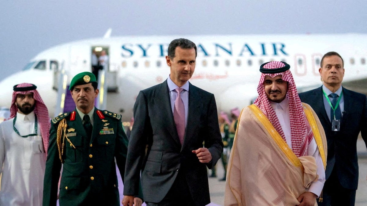 Sirijski predsjednik Bashar al-Assad hoda po pisti u Jeddahu, Saudijska Arabija sa zrakoplovom iza sebe