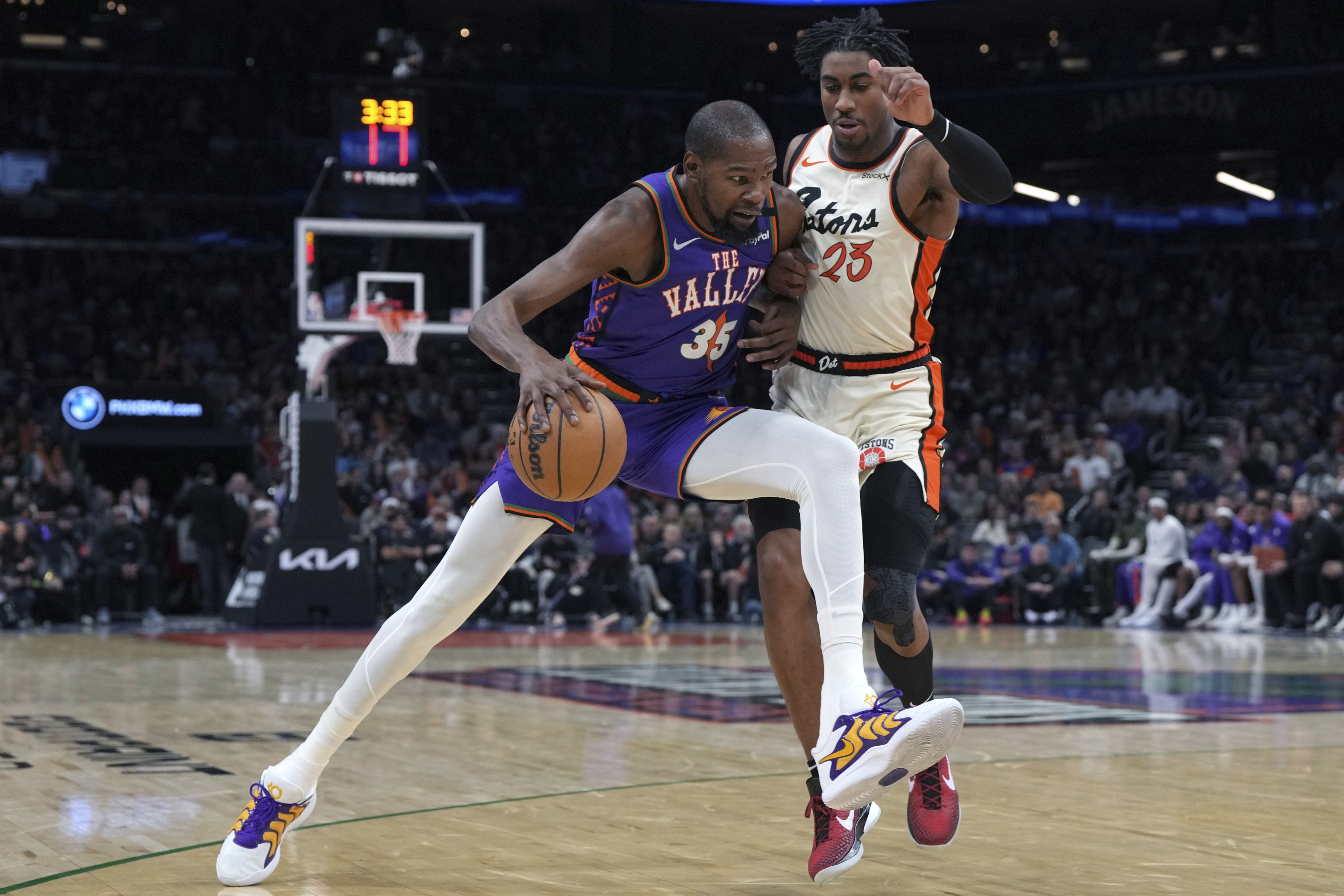 Napadač Phoenix Sunsa Kevin Durant (35) vozi protiv čuvara Detroit Pistonsa Jadena Iveya, desno, tijekom drugog poluvremena NBA košarkaške utakmice, u subotu, 21. prosinca 2024., u Phoenixu. (AP Photo/Rick Scuteri)