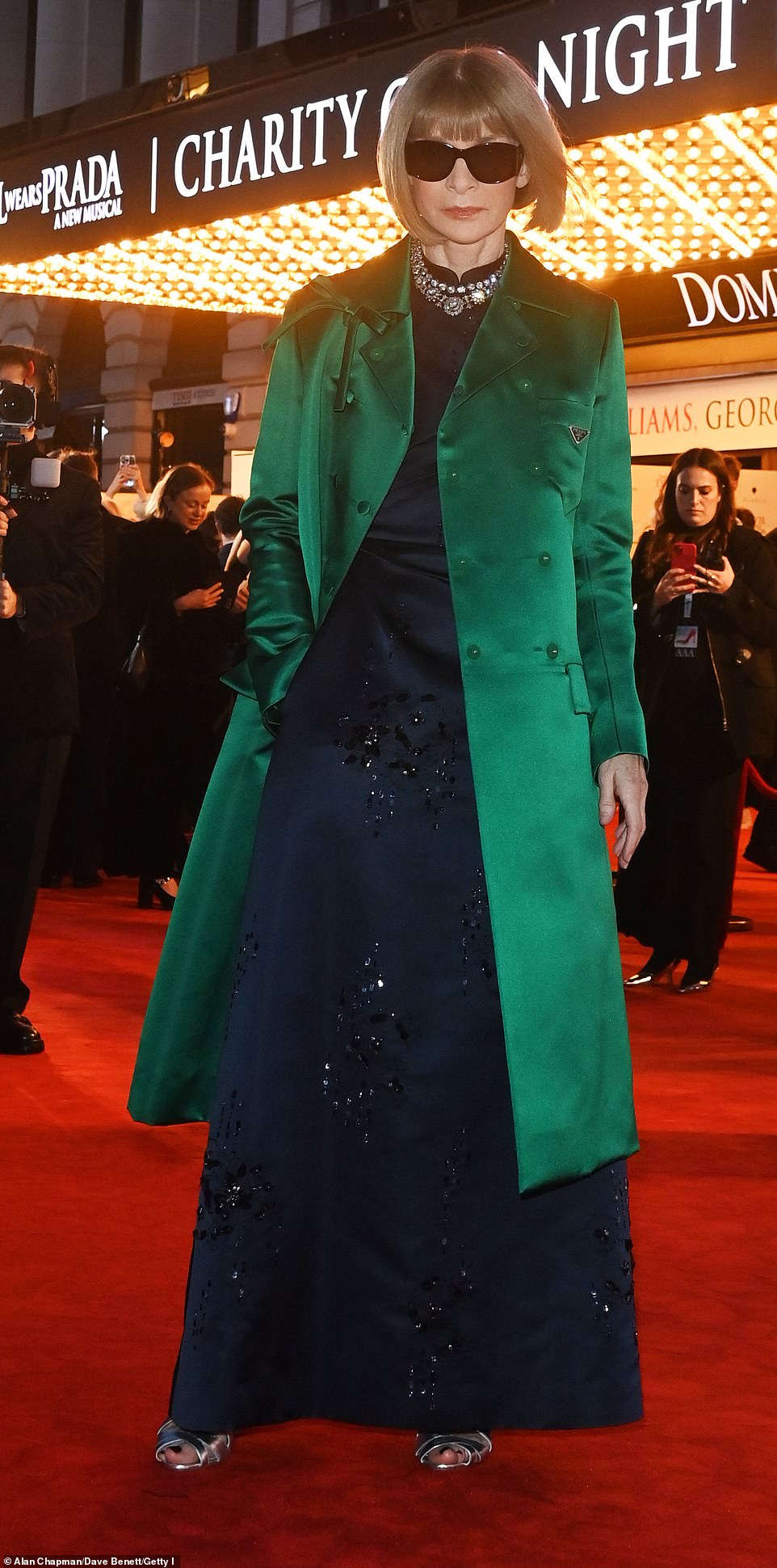 Vogue's Anna looked effortlessly stylish in a navy bejewelled gown and satin emerald overcoat