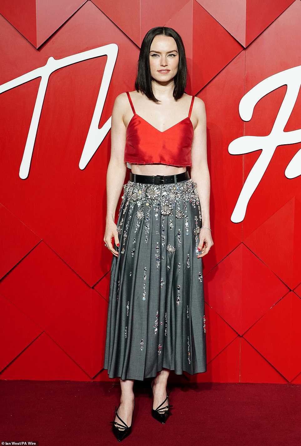 Daisy Ridley kept it simple in a red silk crop top and long dark grey pleated skirt which was adorned with silver sequins