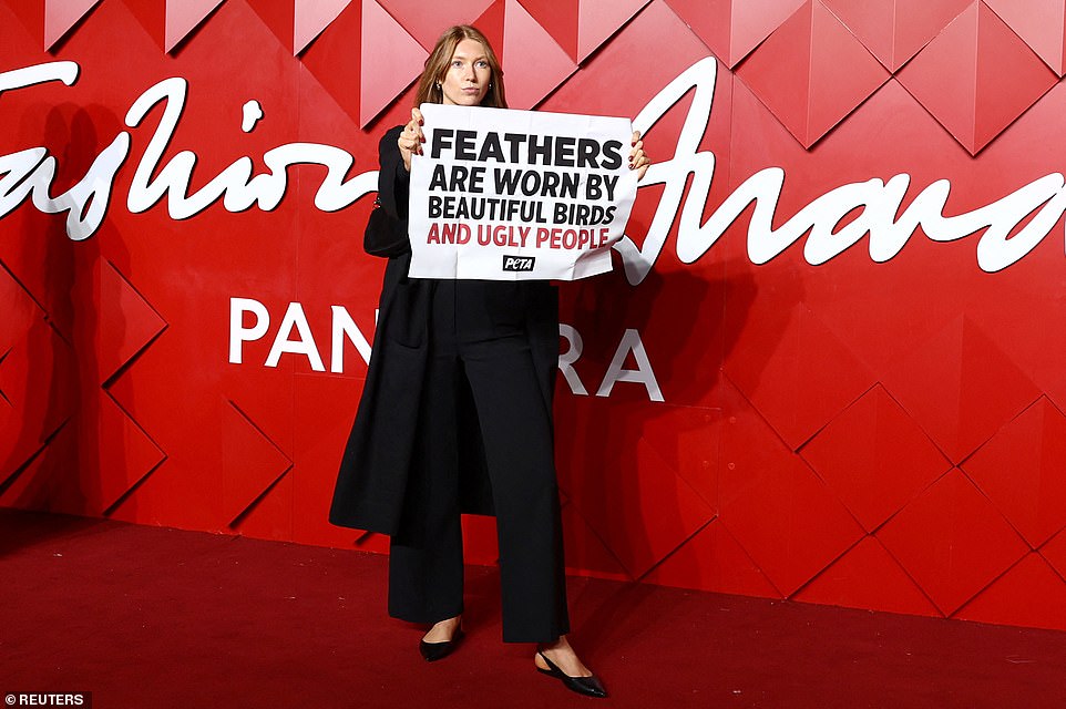 The red carpet was momentarily disrupted by PETA protestors as one woman took to the carpet with a sign which read: 'Feathers are worn by beautiful birds not ugly people'